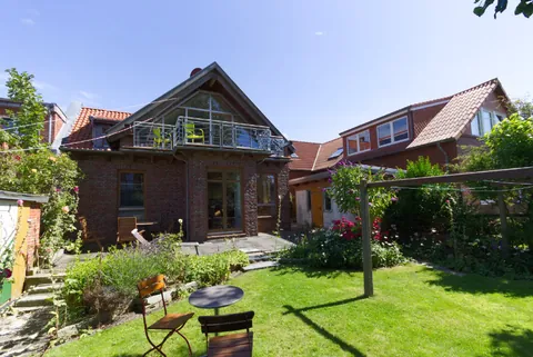 Rückansicht des Vormannshuus mit Garten, Rasenfläche und Gartenmöbeln