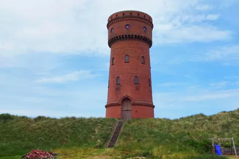 Roter Backstein-Wasserturm von Borkum auf einer grünen Düne